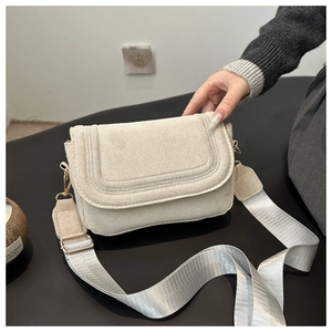 Dettaglio della borsa a tracolla in feltro panna con cuciture e tracolla in nylon
