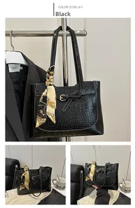 Detail of black crocodile texture tote bag with vintage silk scarf and gold metal buckle