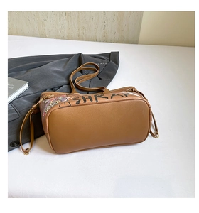 Detail of vintage brown tote bag with graffiti art on premium faux leather surface