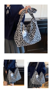 Detail of black and white leopard print canvas tote bag with plush doll charm accessory