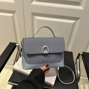 Borsa a sella azzurra in pelle intrecciata con fibbia a U argento e tracolla sottile