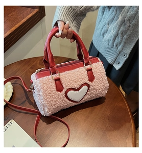 Vue détaillée du sac à main en peluche rose avec cœur et bordure en cuir rouge