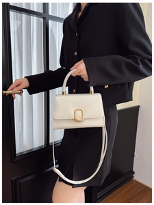 Detailed close-up of white crocodile pattern texture with golden oval buckle closure