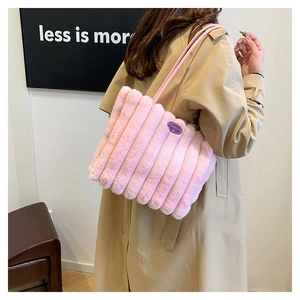 Détail d'un cabas en peluche rose avec texture rayée sur un trench-coat kaki