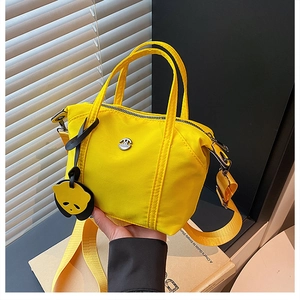 Detail of yellow nylon crossbody bag with metal logo and cute panda head charm