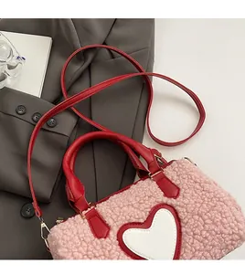 Detail of pink plush heart bag showing faux lamb wool texture and red leather handles