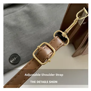 Close-up of adjustable brown leather strap with gold metal buckle and neat stitching