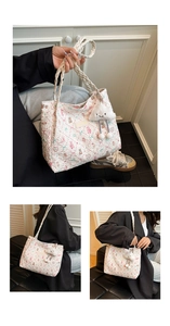 Detail of white quilted tote bag with floral bear patterns and plush cloud charm