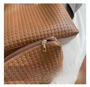 Dettaglio della pelle intrecciata marrone caramello con cerniera rettangolare argento