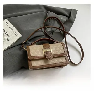 Detail view of contrast color crossbody bag with phone for scale and texture display