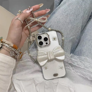 Détail de la coque iPhone à nœud scintillant avec bandoulière en perles nacrées