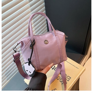 Vue détaillée du sac cabas en nylon lilas avec logo M en métal et pendentif panda mignon