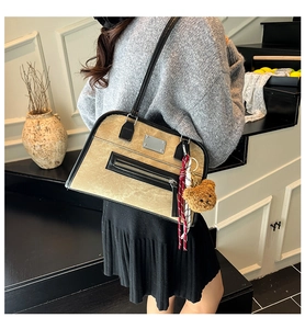 Détail du sac cabas rétro kaki avec pendentif ours et foulard en soie sur l'épaule