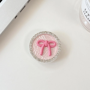 Close-up of pink bow knot phone socket with sparkling rhinestones and woven texture