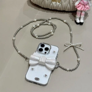 Détail de coque iPhone avec nœud 3D pailleté et chaîne bandoulière en perles et métal