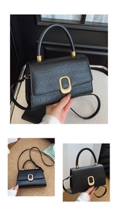 Detail of black crocodile pattern handbag with gold hardware and removable shoulder strap