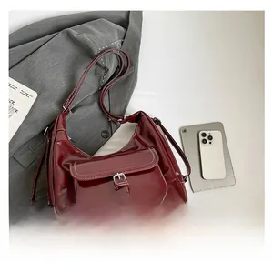 Close-up of burgundy tote bag with white contrast stitching and metal buckle detail
