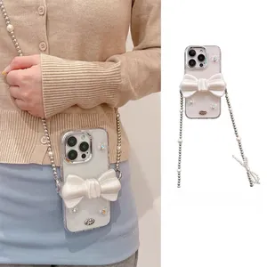 Détail de coque iPhone avec nœud 3D à paillettes, bandoulière en perles et logo métal