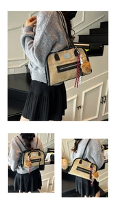 Détail d'un sac cabas beige multifonction avec sangles noires et breloque ours en peluche