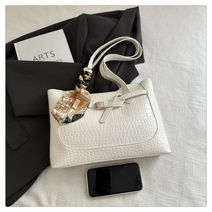 Detail of white crocodile texture tote bag with silk scarf and decorative buckle
