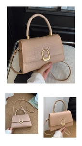 Detail of beige crocodile pattern handbag featuring a gold square metal clasp and top handle