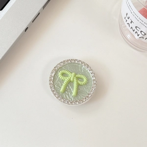 Close-up of light green leather phone grip with crystal rhinestones and a 3D bow