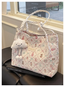 Dettaglio della borsa tote bianca con stampe di animali e ciondolo a nuvola