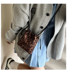 Détail du petit sac bandoulière léopard avec cordon de serrage et fini satiné brillant