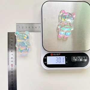 Macro shot of 30g laser bear crystal phone stand showing 7cm height on a scale and ruler