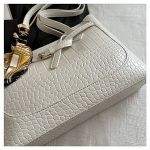 Close-up of white crocodile embossed tote bag with elegant geometric pattern silk scarf