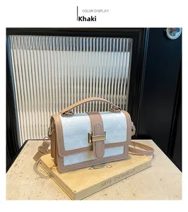 Detail of khaki and white patchwork bag showing textured geometric pattern and gold clasp