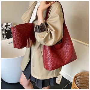 Dettaglio della borsa tote intrecciata rossa e pochette con texture in pelle PU intrecciata