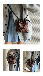 Détail du sac seau à motif léopard avec fermeture à cordon et boules métalliques argentées