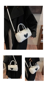 Macro detail of white faux fur pillow bag featuring a bold black heart patch and gold chain