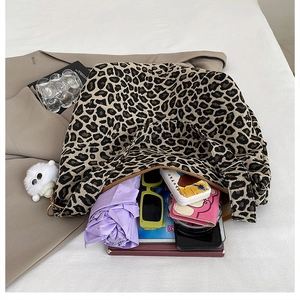Detail showing the large capacity of a leopard print canvas tote bag with daily essentials