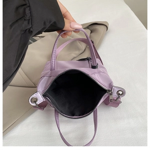 Vue intérieure d'un petit sac fourre-tout en nylon violet avec doublure et zip métal