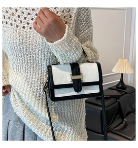 Detail of vintage small square bag with geometric embossing and contrast colors on model