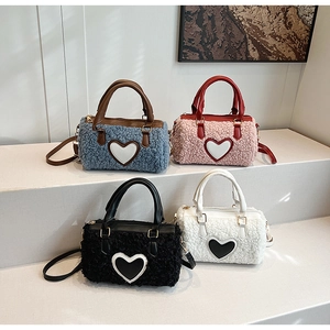 Detail of colorful fluffy faux lamb wool cylinder bags with leather handles and heart patch