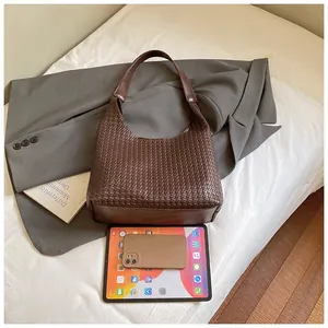 Dettaglio della borsa tote intrecciata marrone scuro con grande capacità e trama in pelle