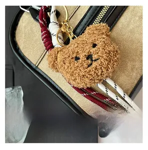 Détail d'un pendentif ours en peluche avec corde tressée sur un sac en toile