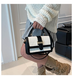 Detail of the black and white geometric embossed shoulder bag with gold buckle