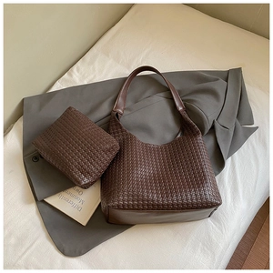 Dettaglio della borsa tote in pelle intrecciata marrone scuro con pochette coordinata