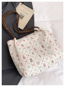 Dettaglio della borsa tote plissettata bianca con stampe di orsi e tracolle intrecciate