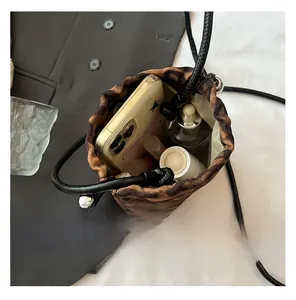 Vue intérieure du sac seau léopard montrant le rangement pour téléphone et cosmétiques