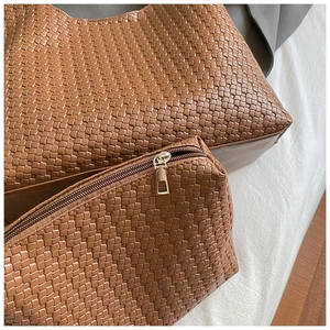 Dettaglio della trama intrecciata in ecopelle marrone sulla borsa tote e pochette