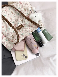 Detail showing the large storage capacity of this floral quilted tote bag with everyday items