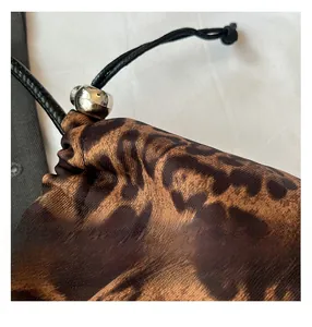 Vue détaillée du tissu imprimé léopard avec cordon noir et perle en métal argenté