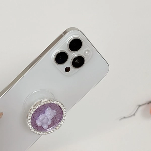 Detail showing a purple bear phone socket with sparkling rhinestones on white phone