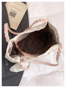 Detailed view of floral bear tote bag featuring a pink woven handle and plush charm