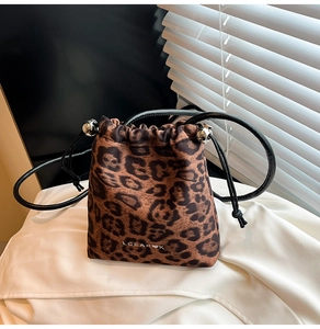 Close-up of leopard print bucket bag with drawstring closure and silver metal beads